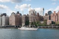 Beautiful big white sailboat on East River. Manhattan`skyscrapers on background