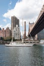 Beautiful big white sailboat on East River. Queensboro bridge and Manhattan`skyscrapers on background