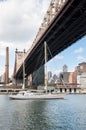 Beautiful big white sailboat on East River. Queensboro bridge and Manhattan`skyscrapers on background