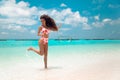 Beautiful bikini Woman with long hair jumping on tropical beach. Pretty slim girl posing on exotic island in turquoise ocean. Royalty Free Stock Photo