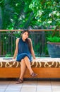 Beautiful biracial teen girl sitting on cushioned bench outdoors Royalty Free Stock Photo