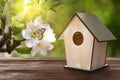 Beautiful bird house on wooden table outdoors, space for text Royalty Free Stock Photo