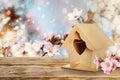 Beautiful bird house on wooden table outdoors, space for text Royalty Free Stock Photo