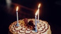 Beautiful birthday cake with three blue candles for a holiday for a boy of 3 years old. Blurred dark background. Close-up Royalty Free Stock Photo