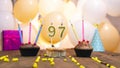 A beautiful birthday card for a woman with the number 97 in a cupcake against the background of balloons. Happy birthday