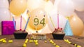 A beautiful birthday card for a woman with the number 94 in a cupcake against the background of balloons. Happy birthday