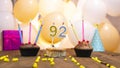 A beautiful birthday card for a woman with the number 92 in a cupcake against the background of balloons. Happy birthday