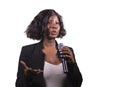 Beautiful black afro American business woman with microphone speaking in auditorium at corporate event or seminar giving Royalty Free Stock Photo