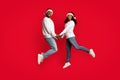 Beautiful black couple in Santa hats holding hands and jumping Royalty Free Stock Photo