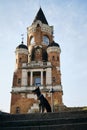 Beautiful black dog sits and poses near Gardos Tower -Millenium Tower- in Belgrade, Serbia. Old town Zemun district