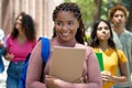 Beautiful black female student with dreadlocks and group of latin american and caucasian young adults Royalty Free Stock Photo