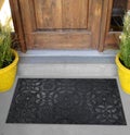 Beautiful Black Grey Sacred Pattern Rubber Glitter door mat with yellow flowers and leaves Royalty Free Stock Photo