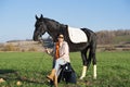 Beautiful black horse  with his owner and rider  posing in green grass meadow. autumn season Royalty Free Stock Photo