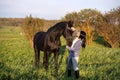 Beautiful black horse  with his owner and rider  posing in green grass meadow. spring time Royalty Free Stock Photo