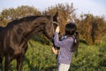 Beautiful black horse  with his owner and rider  posing in green grass meadow. spring time Royalty Free Stock Photo