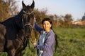 Beautiful black horse  with his owner and rider  posing in green grass meadow. spring time Royalty Free Stock Photo