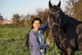 Beautiful black horse  with his owner and rider  posing in green grass meadow. spring time Royalty Free Stock Photo