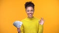 Beautiful black lady showing bunch of dollars and ok gesture, cash-back service Royalty Free Stock Photo