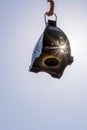 A black lantern suspended in the air is struck by the rays of the sun looking lit.