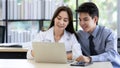 Beautiful black long hair Asian businesswoman and cute Asian businessman working together in office with intimate Royalty Free Stock Photo