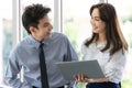 Beautiful black long hair Asian businesswoman standing watching the screen of laptop notebook computer and talking with Royalty Free Stock Photo