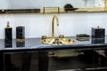 A beautiful black marble washbasin with a gold tap and fittings. Gold sink, led mirror, marble black dispensers Royalty Free Stock Photo