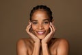 Beautiful black middle aged woman touching her face and smiling at camera, enjoying beauty treatments and selfcare Royalty Free Stock Photo