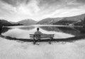 Beautiful black and white at park. Man is sitting on bench and bicycle lane, mountain lake in the Alps, Zell am See, Royalty Free Stock Photo