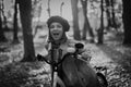 Beautiful black and white portrait of young smiling woman in french beret cycling alone in park. Sunny day in forest Royalty Free Stock Photo