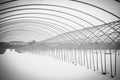 Beautiful black and white shot of a snowy roadway with metallic arches