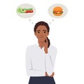 Beautiful black woman choosing between salad and hamburger, healthy and junk food Royalty Free Stock Photo