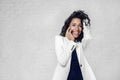 Beautiful black woman speak by mobile phone in white suit, brick wall Royalty Free Stock Photo