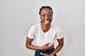 Beautiful black woman standing over isolated background smiling and laughing hard out loud because funny crazy joke with hands on Royalty Free Stock Photo