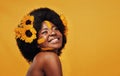 Beautiful black woman, sunflowers in hair and make up on face in studio for cosmetics, afro care and empowerment. Happy Royalty Free Stock Photo