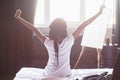 Beautiful black woman waking up in her bed, she is smiling and stretching Royalty Free Stock Photo