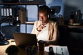 Beautiful black woman working at the office at night asking to be quiet with finger on lips Royalty Free Stock Photo