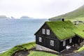 Beautiful black wooden house with green grass on the roof, sea s Royalty Free Stock Photo