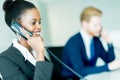 A beautiful, black, young woman working at a call center in an o Royalty Free Stock Photo
