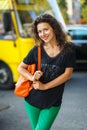 Beautiful blackhaired model girl posing for cloth and bags promotion at city streets background