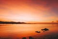 Beautiful blazing sunset landscape at black sea and mountain above orange sky with awesome sun golden reflection on calm sea as Royalty Free Stock Photo