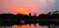 Beautiful blazing sunset landscape at over the meadow and orange sky above it. Amazing summer sunrise as a background. Royalty Free Stock Photo