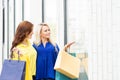 Beautiful blond and brunette walking along shop-windows Royalty Free Stock Photo