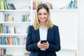 Beautiful blond businesswoman with tracing app at mobile phone
