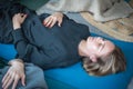 Beautiful blond Caucasian girl lying on a mat, breathing and meditating