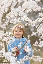 Beautiful blond child, boy, holding twig, braided whip made from pussy willow, traditional symbol of Czech Easter used for