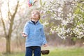 Beautiful blond child, boy, holding twig, braided whip made from pussy willow, traditional symbol of Czech Easter used for