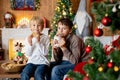 Beautiful blond child and his older brother, young school boys, playing in a decorated home with knitted toys