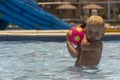 Beautiful blond child playing ball in the pool Royalty Free Stock Photo