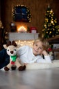 Beautiful blond child, young school boy, playing in a decorated home with knitted toys Royalty Free Stock Photo