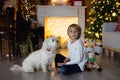 Beautiful blond child, young school boy, playing in a decorated home with knitted toys Royalty Free Stock Photo